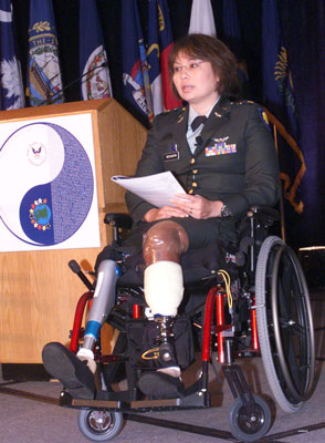 Photo: Assistant Secretary Duckworth, who sits in a wheelchair alongside a podium, has two prosthetic legs