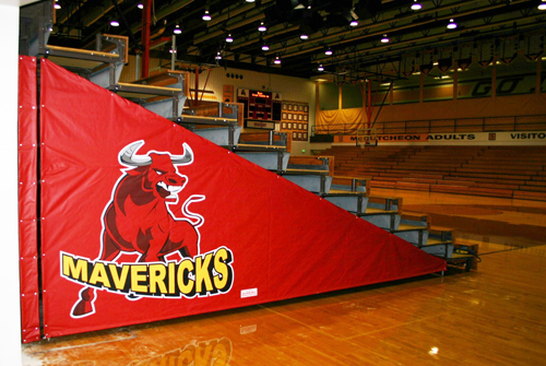 Vinyl end closure with school logo covers the end of a set of gym bleachers