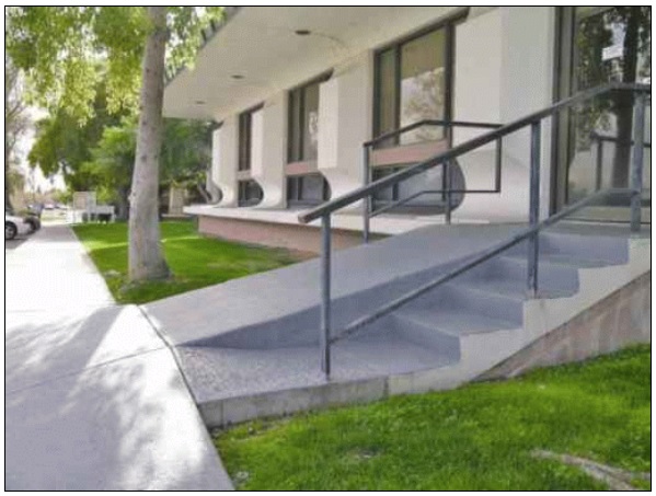 Too-steep entrance ramp without handrails and edge protection
