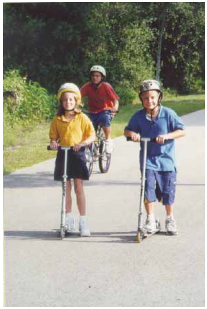 Figure 2: Photo. Nonmotorized kick scooter. A boy and girl are using nonmotorized kick scooters on a trail