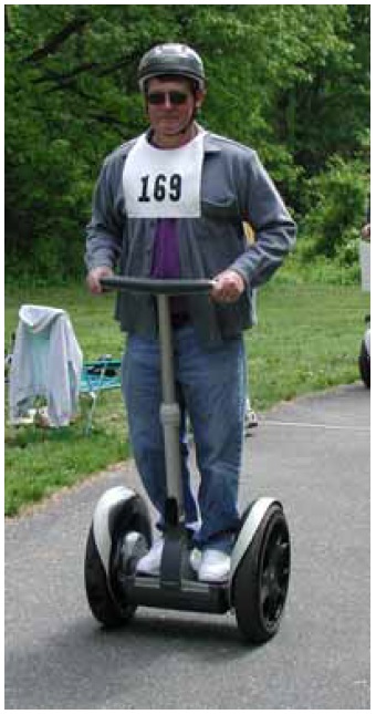 Figure 6: Photo. A Segway user. A man is using a Segway to travel on a trail.
