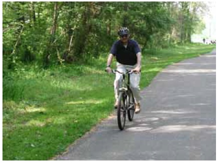 Figure 56: Photo. Many volunteers participated in the "Ride for Science" events. A participant is riding his bicycle on a trail.