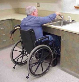 Photo of a man in a wheelchair using an accessible sink faucet