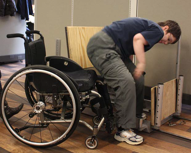 This figure shows an ambulatory manual wheelchair-using subject transferring to the station with a 7in gap between the WMD and the station.  The transfer station height is level with the height of the wheelchair seat to the ground. 
