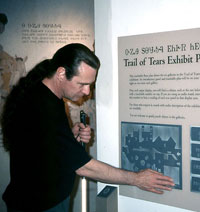 Man who is blind examines raised-line exhibit floor plan in museum
