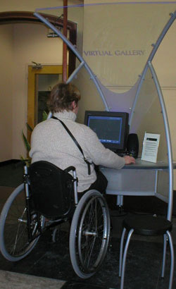 Woman seated in wheelchair operating a computer-based museum interactive
