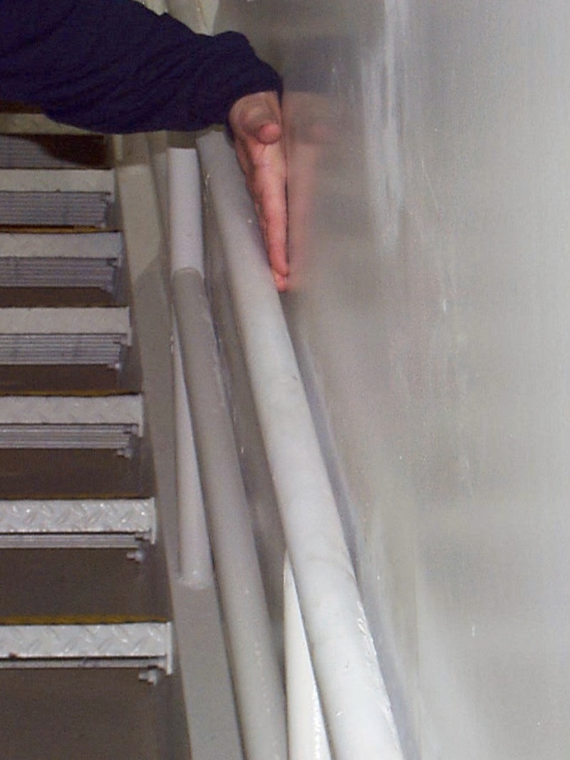 person gripping a handrail in a stairway