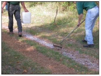 Application of Soil-Sement to bridle trail by drip-bucket method. Rakes were used to mix binder with EWF and level the trail. 