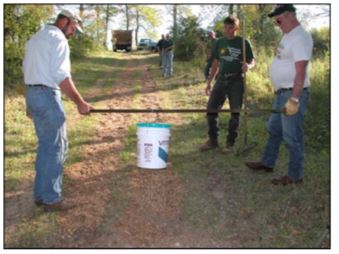 Application of Vitri-Turf to bridle trail by dripbucket method. Holes drilled in bottom of 19-L (5-gal)
container allowed uniform application over 0.4- by 20-m (1.3- by 66-ft) trail.