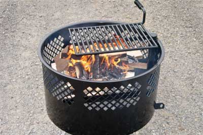 Photo of a fire burning in a metal fire ring.  The lower part of the ring is solid metal and the upper part is diamond patterned mesh.