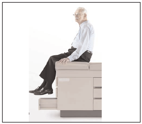 man sitting on a standard exam table
