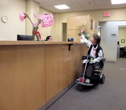 Image showing a person on a mobility scooter at a non-accessible reception desk 