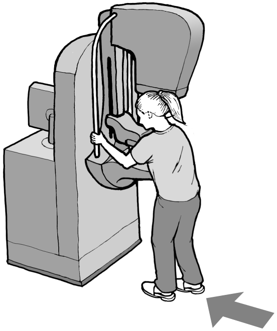 Woman standing and holding onto supports of the mammography machine shown in the overview image.&nbsp; The machine is adjusted up in height to accommodate a standing position.
