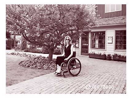 photo of woman in wheelchair on brick-paved path