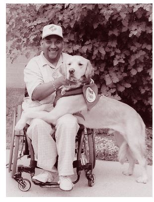Lawrence W. Dilworth, Jr in his wheelchair,holding a service dog