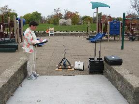 A data collector records the findings from a playground in the research study where the rotational penetrometer is set up at the entry.