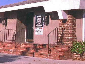 view of the entrance to a restaurant which has three steps. A sign on the front has we deliver and the telephone number. 