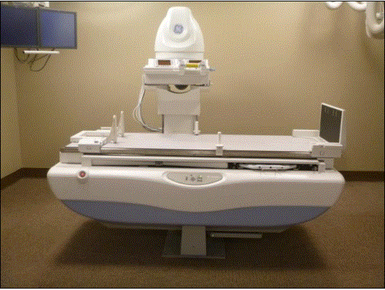 This picture shows a side view of an Angulating Radiographic and Fluoroscopic Exam Table whose fixed height is approximately 34.5 inches. The height is the result of the design being able to angulate to perform certain types of diagnostic exams and also to accommodate imaging components under the table such as X-Ray tubes, high voltage generators, and detectors. The table surface is also able to move in two directions horizontally. Also note the equipment imaging components on the opposite side of where the patient transfers.