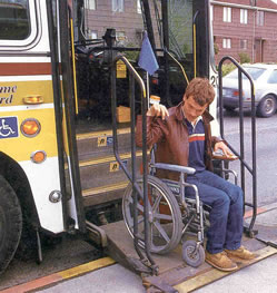 Man using wheelchair lift to access a public bus.