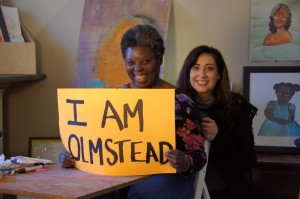 Lois Curtis, holding sign, an artist and one of the two women with disabilities who filed the lawsuit that resulted in the 1999 U.S. Supreme Court Olmstead v. L.C. decision.