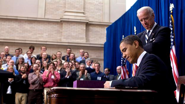President Barack Obama signs The American Recovery and Reinvestment Act.