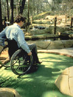 photo of man in wheelchair on a miniature golf course
