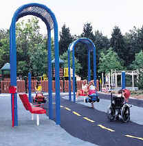 photo of a play area with protective shelters and benches offset from the boundary of the accessible route