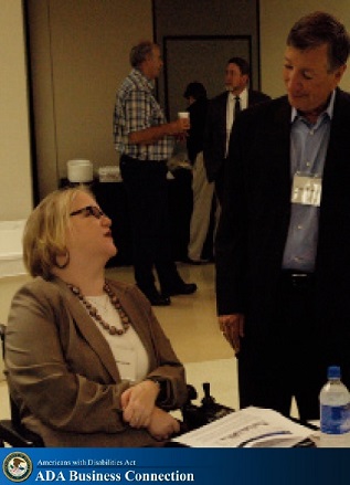Woman in a wheelchair talking with another conference attendee